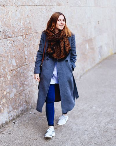 Grey coat, blue striped shirt, jeans and white sneakers